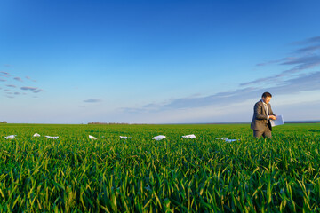Fototapeta premium businessman lays out reports on a green grass field, the concept of work and freelancing