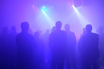 Fototapeta na wymiar Crowd in foggy dancefloor at the concert
