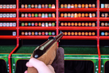 Shooting a weapon at an entertainment shooting range. Selective focus on rifle rear sight and...