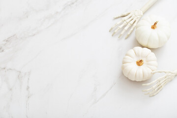 Fototapeta na wymiar white halloween pumpkins with decor on marble background