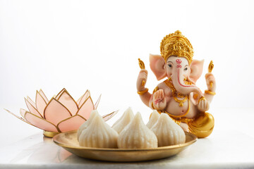Idol of lord Ganesha with Modak Sweet Dish and flower. Ganesh chaturthi