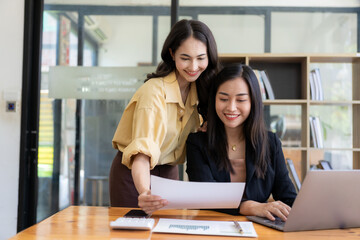 Two female Asian accountants discuss financial management planning. Analysis of new startup project ideas