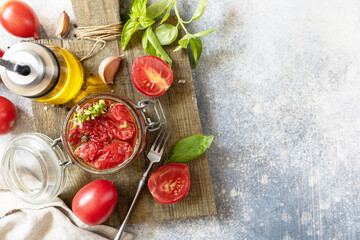 Healthy homemade fermented food. Sun-dried tomatoes in jar with spices and herbs. Home economics, autumn harvest preservation. View from above. Copy space.