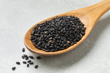 Wooden spoon with black roasted sesame seeds close up