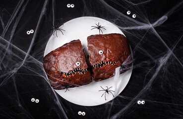 Halloween food. Spooky cake with eyes and spiders on a dark background in a web. Terrible food....