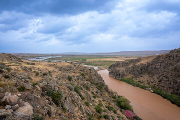 River blurred by rain, flowing through the canyon