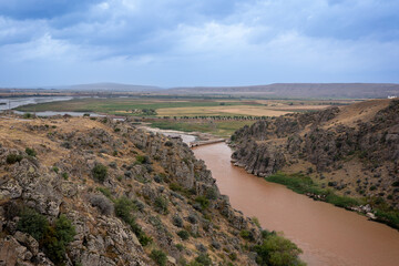 River blurred by rain, flowing through the canyon