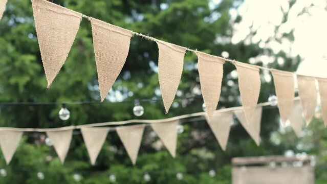 Summer Nights Redefined: Elevate your outdoor gatherings with beige triangle flags and soft-glowing light bulbs. Embrace this enchanting setup to enhance conversation and camaraderie as dusk falls