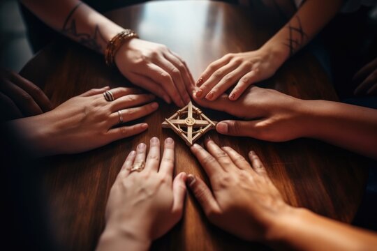 shot of a group of people forming a masonic symbol with their hands while sitting together