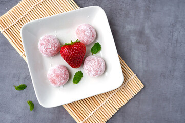 Traditional Japanese dessert, strawberry mochi on a plate.
