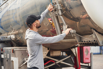 Quality control. Young truck driver in casual clothes