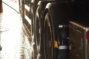 Man is washing the big vehicle indoors. Close up view