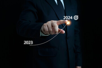 Businessman pointing arrow corporate future growth plan,Businessman hand pointing arrow plan from 2023 to 2024 ,Business development to success and growing growth concept. business success target.