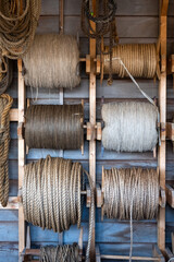 Skeins of bast twine for boat on the wall, large spools of rope.