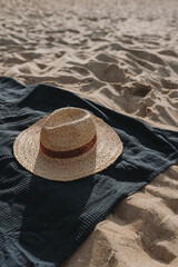 Sunglasses, straw hat and beach towel on beach sand. Minimal aesthetic lifestyle fashion blog, magazine, social media. Sunbathe, relax, chill on summer travel vacations