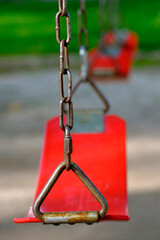 Red Swings Swingset Hanging in a Row for Childhood Fun