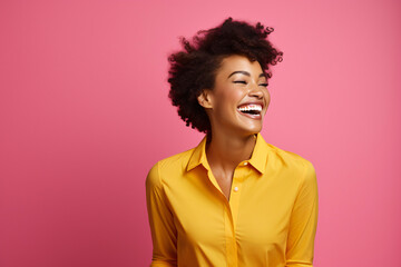 Fototapeta na wymiar laughing young black woman in front of a pink background