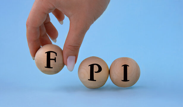 A woman's hand holds a wooden ball with the abbreviation FPI .