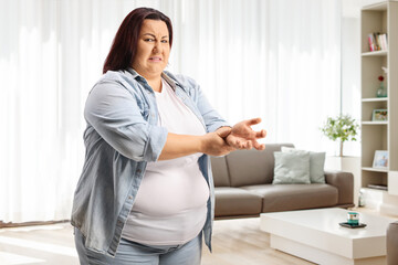 Overweight woman measuring pulse on hand wrist at home