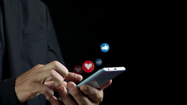 Businessman using a social media marketing concept on mobile phone with notification icons of like and love above smartphone screen. Technology communication network online concept.