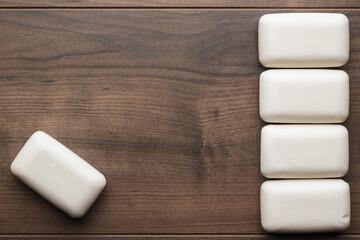 Some soap bars on the brown table. Flat lay photo of the soap bars on wooden background with copy space.