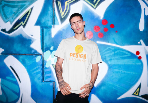 Mockup of man wearing t-shirt with customizable color with artwork in background