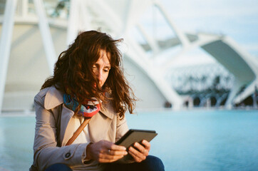 Baby boomer woman reading kindle e-book in futuristic city
