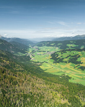 Aerial view of Dobbiaco town as seen from Croda dei Baranci (Birkenkofel) mountain peak on the Dolomites range, Trentino, South Tyrol, Italy.