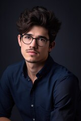 Fototapeta premium studio shot of a handsome young man holding his glasses against a gray background