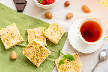 tea, milk, cakes, chocolate pieces, halva on the table