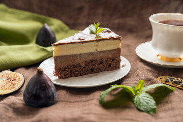 chocolate cake on white plate and tea with figs 