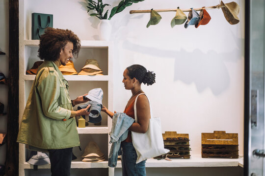 Couple buying hats while standing together at fashion boutique