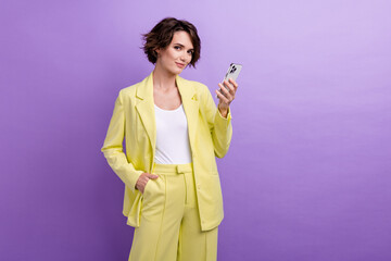 Photo of confident lady business analytics holding modern apple iphone 15 best gadget for influencers isolated on purple color background