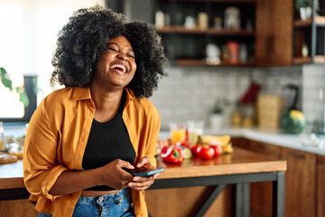 Portrait of a young woman texting and laughing