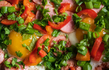 fried eggs eggs with green onions, sausages and red peppers