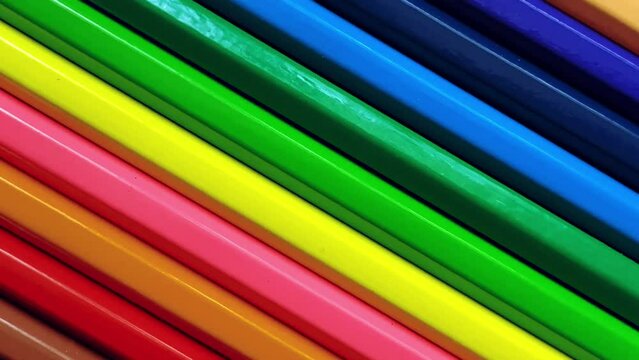 Close-up of arranged colored pencils forming lines, rotating.