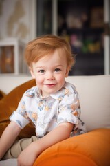 Fototapeta premium portrait of an adorable little boy sitting on the sofa at home