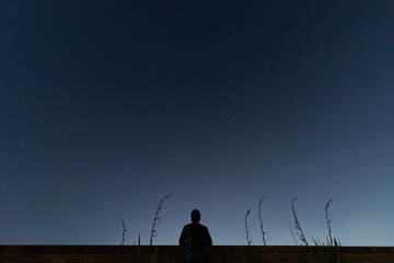 Young man watching blue sky with  faint stars 