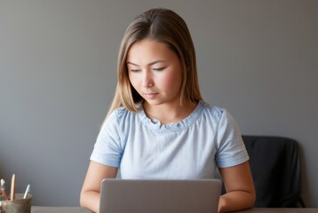 Naklejka premium Asian girl school student e learning distance training course study work at home office. Ethnic young woman watching online education webinar using laptop