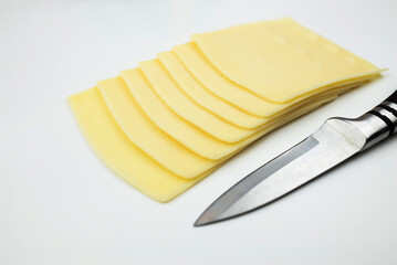 cheese slices and knife on white