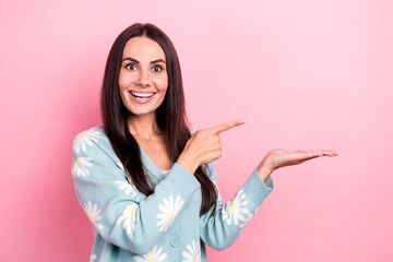 Photo of overjoyed impressed woman dressed blue cardigan directing at palm show proposition empty space isolated on pink color background