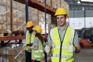 Portrait of male warehouse worker working and wearing safety uniform and helmet at warehouse storage
