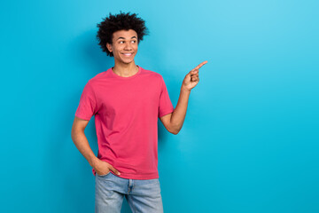 Photo of funky positive man wear trendy clothes looking interesting offer empty space isolated on blue color background