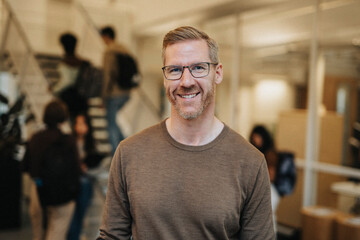 Portrait of smiling mature professor standing in university