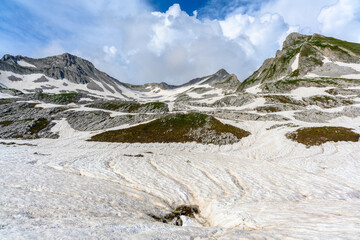 Obraz premium The snowdrifts and green grass on top of mountains in the tropical forest.