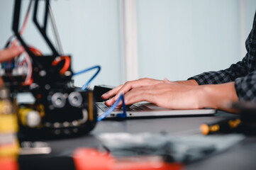 Engineer Asian Students Assembling Robotics Kits. Learning Mechanical Control by Computer, Robotics combines computer, electrical, mechanical, and sensing. Empowering Engineers and Development.