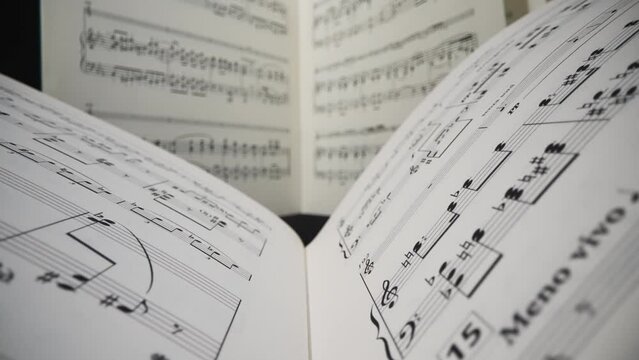 Super macro view of camera moving through sheet music with musical notes.