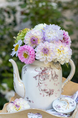 Blumenstrauß mit weißen und pink Dahlien uns Astern in vintage Kaffeekanne