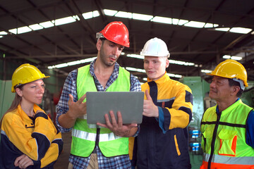 Professional male and female industrial engineers or technicians walking in the abandoned factory to inspect the machines and construction. Team of engineer have a discussion in factory.
