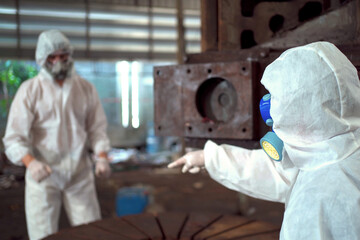 Team of scientist wearing a chemical protection suit and high efficiency filter face mask working...